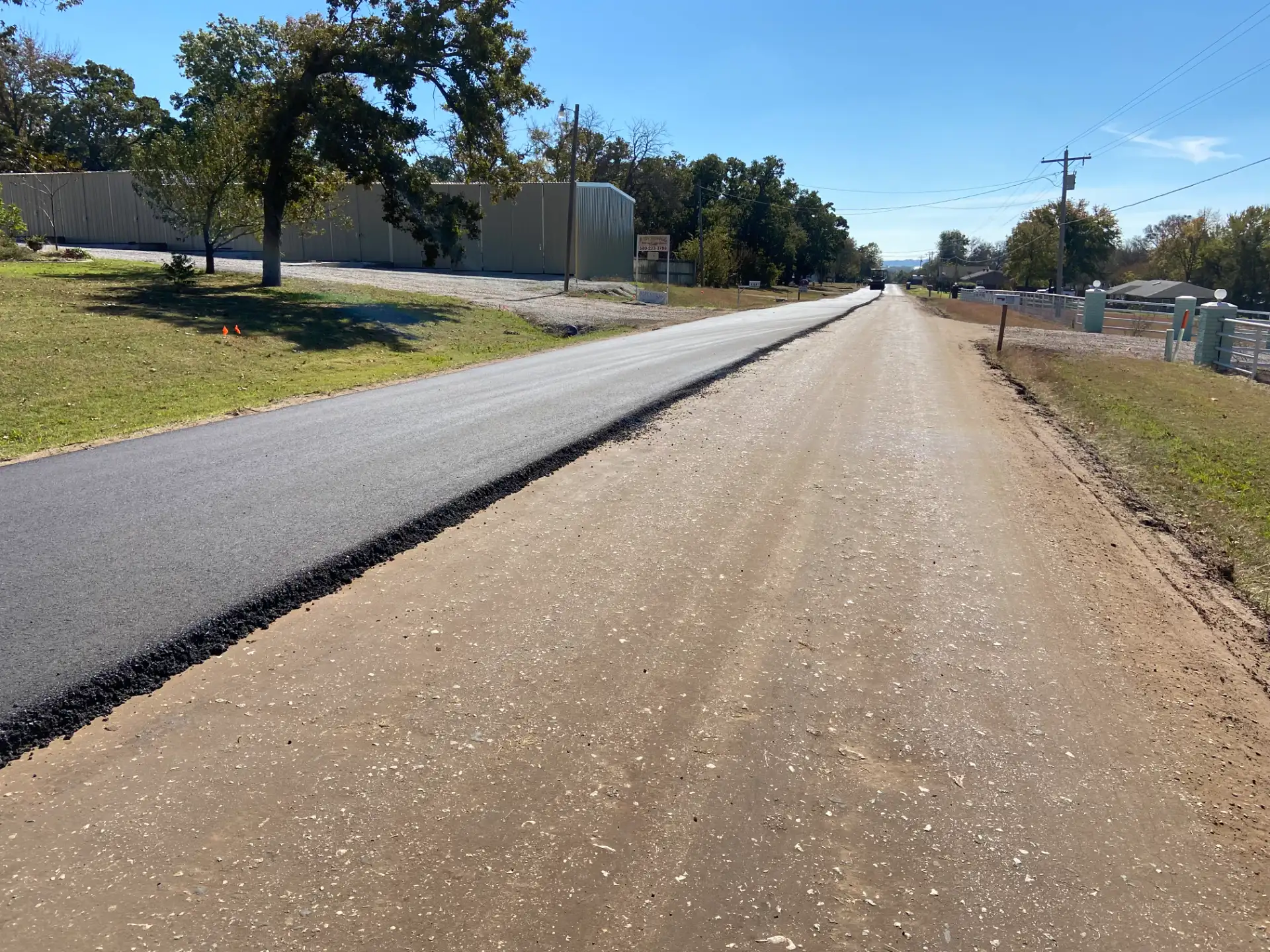 Fresh asphalt laid beside a stabilized road base
